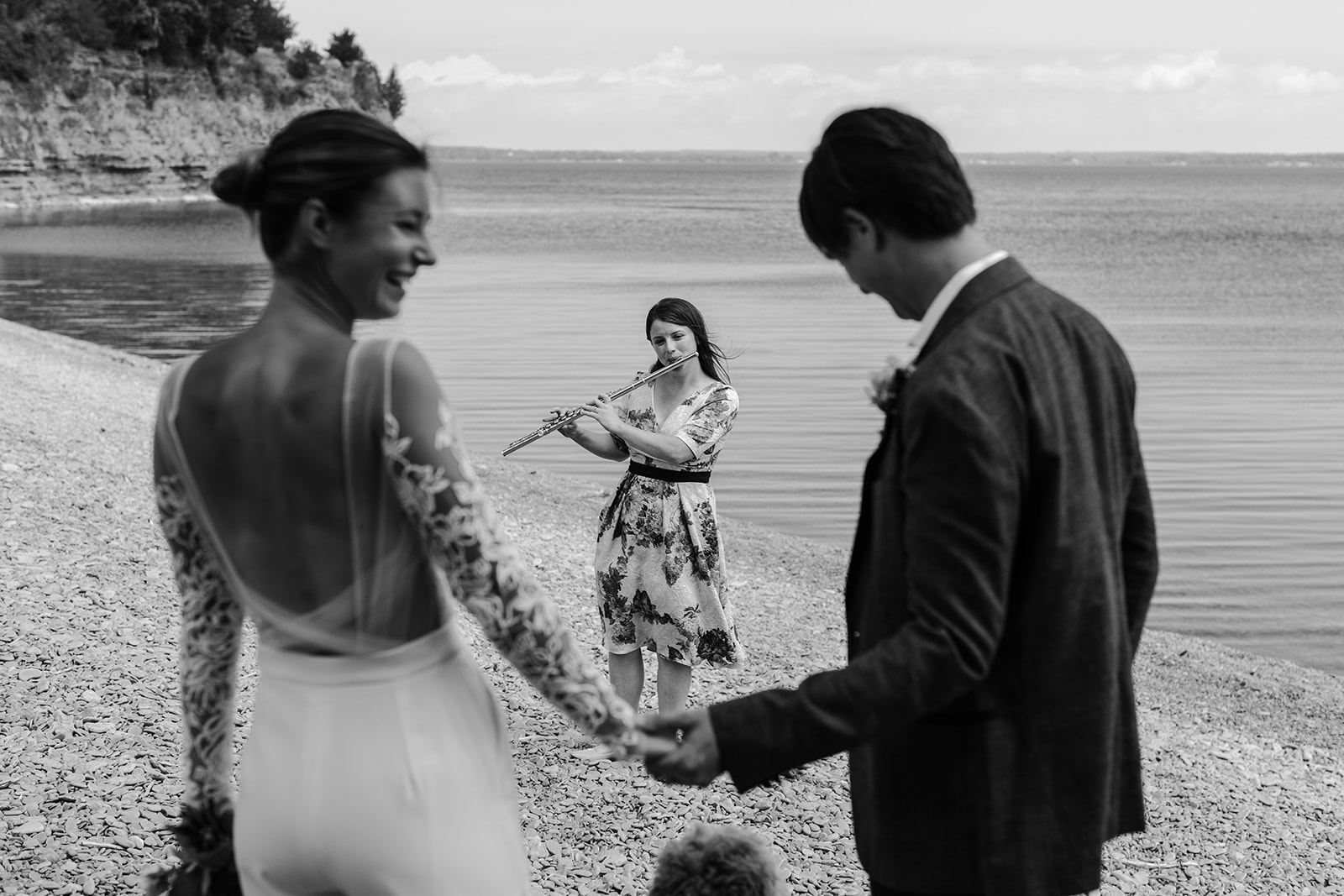 Couple with their friend playing flute during their Elopement at Little Bluffs, PEC